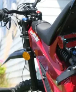 Talaria X3 Pro electric dirt bike in red, side view parked outside a shop in Australia