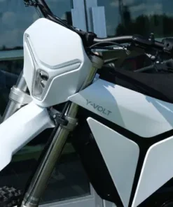 Side profile of a white Volt Surge V electric dirt bike showcased outdoors in Australia, featuring aggressive knobby tyres, inverted front forks, rear mono-shock suspension, and a compact battery/motor unit — ideal for Aussie trail riders seeking a quiet, zero-emission off-road bike